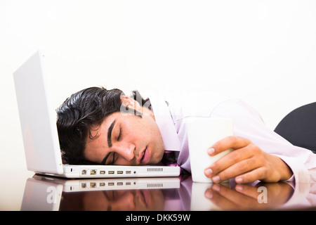 Junge indische Geschäftsmann schlafen am Arbeitsplatz Stockfoto