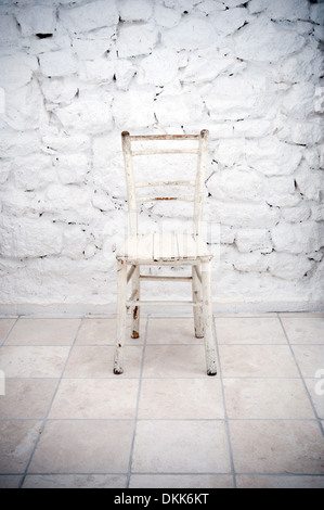 Alten Holzstuhl vor Steinmauer Stockfoto