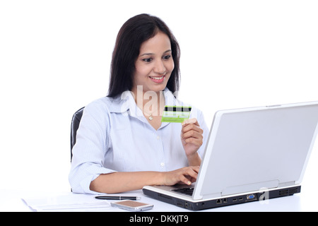 Glückliche junge Geschäftsfrau, die Online-Einkäufen gegen weiß Stockfoto