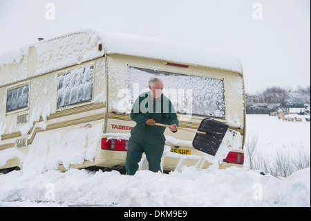 Resident Ron Webber gräbt aus seinem Wohnwagen in Schnee bedeckt, Challacombe, Devon, UK im Winter. Stockfoto