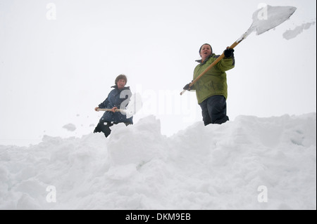 Bauern Graben Sie die Schnee bedeckten Einfahrt in der Nähe vom Dorf Bratton Fleming, Devon, UK im winter Stockfoto