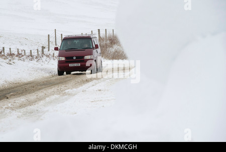 Ein van fährt durch Schneeverwehungen auf Exmoor im Winter, UK Stockfoto
