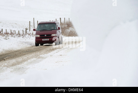Ein van fährt durch Schneeverwehungen auf Exmoor im Winter, UK Stockfoto