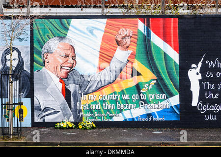 Belfast, Nordirland. 7. Dezember 2013 - links Floral Hommagen an Mandela Wandbild nach dem Tod von Nelson Mandela am 5. Dezember. Bildnachweis: Stephen Barnes/Alamy Live-Nachrichten Stockfoto