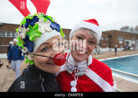 London, UK. 7. Dezember 2013. Frau mit einem Rudolf die rote Nase Rentier und Santa-Outfits. Mehrere hundert mutige Schwimmer, viele saisonale verkleidet, verspannt die Kälte (Wassertemperatur 6° C, Lufttemperatur 9° C) und nahm einen Sprung auf der Outdoor Swimming Society annual Dezember Dip im Parlament Hill Lido auf North London Hampstead Heath. Foto. Nick Savage/Alamy Live-Nachrichten Stockfoto