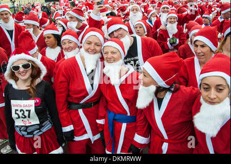 Brighton, East Sussex, UK. 7. Dezember 2013. Weihnachtsmänner zu Beginn des Santa Dash. Hunderte von Läufer aller Altersgruppen, einige Vierbeiner, einige noch nicht aus einem Kinderwagen, verkleiden sich als Weihnachtsmann zur Teilnahme an der jährlichen 5 k Santa Dash laufen entlang der Strandpromenade in Brighton & Hove. Foto © Julia Claxton Credit: Julia Claxton/Alamy Live News Stockfoto