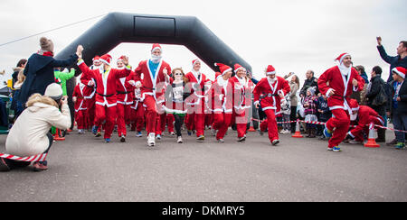 Brighton, East Sussex, UK. 7. Dezember 2013. Weihnachtsmänner zu Beginn des Santa Dash. Hunderte von Läufer aller Altersgruppen, einige Vierbeiner, einige noch nicht aus einem Kinderwagen, verkleiden sich als Weihnachtsmann zur Teilnahme an der jährlichen 5 k Santa Dash laufen entlang der Strandpromenade in Brighton & Hove. Foto © Julia Claxton Credit: Julia Claxton/Alamy Live News Stockfoto