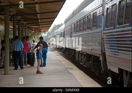 Junge mit Händen über Ohren schützt das laute Geräusch des Zuges nähert sich DeLand Station Florida USA Stockfoto