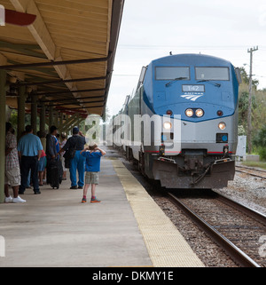 Junge mit Händen über Ohren schützt das laute Geräusch des Zuges nähert sich DeLand Station Florida USA Stockfoto