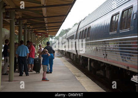 Junge mit Händen über Ohren schützt das laute Geräusch des Zuges nähert sich DeLand Station Florida USA Stockfoto