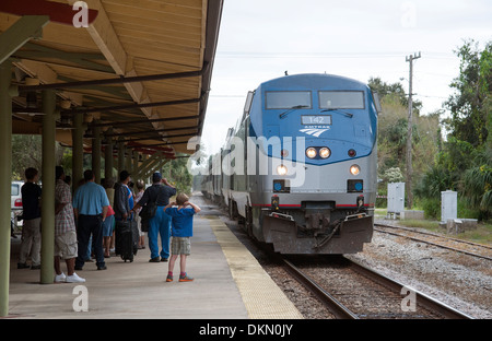 Junge mit Händen über Ohren schützt das laute Geräusch des Zuges nähert sich DeLand Station Florida USA Stockfoto