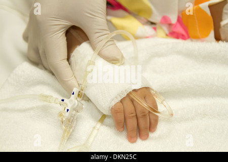 Des Arztes Handpflege für Kinder Patienten mit Kochsalzlösung intravenös (iv) Tropf Stockfoto