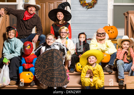 Familie der Eltern und drei Kinder gekleidet im Kostüm für Halloween treating Stockfoto