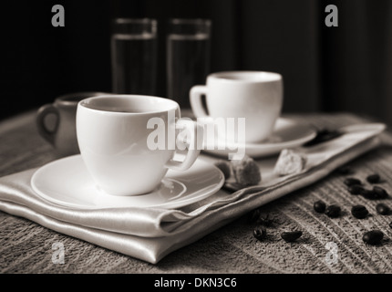 Zwei Tassen dunkel Kaffee, Milch, Wasser, Zucker, Löffel, Kaffeebohnen, hölzernen Hintergrund Stockfoto