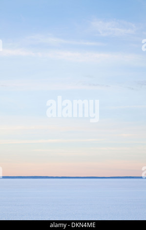 Ein einfacher Blick auf eine gefrorene Lake Simcoe mit Wolkenfetzen am blauen Himmel. Lake Simcoe, Georgina, Ontario, Kanada. Stockfoto