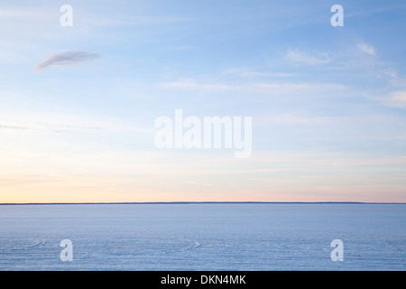 Ein einfacher Blick auf eine gefrorene Lake Simcoe mit Wolkenfetzen am blauen Himmel. Lake Simcoe, Georgina, Ontario, Kanada. Stockfoto