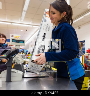 Ein Check-out Frau scannen einen ganze Serrano-Schinken, einer der Discounter Lidl 'Deluxe'-Reihe von Lebensmitteln, UK Stockfoto