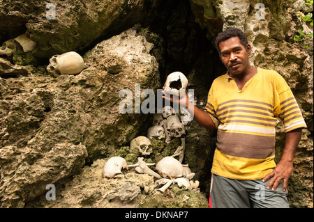 Mann, der Schädel unter den menschlichen Überresten, was, die er sagte, von Feinden getötet und gegessen werden von seinen Vorfahren, renommierten Krieger waren. Fidschi-Inseln Stockfoto