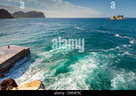 Coastal Steinen und kleinen Pier mit brechenden Wellen. Adria Stockfoto