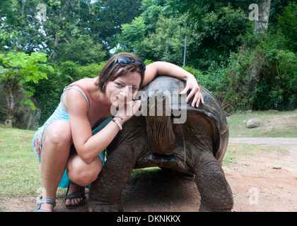 Eine Frau mit einer Riesenschildkröte. La Digue, Seychellen. Stockfoto