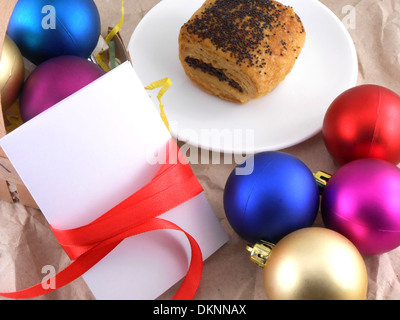 Kuchen mit Weihnachtskugeln und weiße Einladungskarte Stockfoto