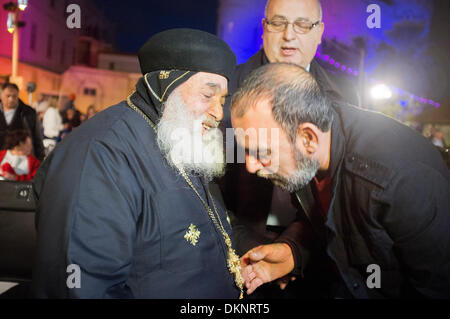 Jaffa, Israel. 8. Dezember 2013. Ein Mann zeigt großen Respekt für christliche Leiter angekommen, um in einen festlichen Weihnachtsbaum Beleuchtung teilzuhaben. Jaffa, Israel. 8. Dezember 2013.  Tel Aviv-Yafo Gemeinde leuchtet einen 15 Meter hohen Weihnachtsbaum, eines der größten in Israel, in die Andromeda compound in Jaffa. In Jaffa, unter Ihnen griechisch-orthodoxe, Katholiken, Maroniten, Kopten und Protestanten leben rund 6.500 Christen. Bildnachweis: Nir Alon/Alamy Live-Nachrichten Stockfoto