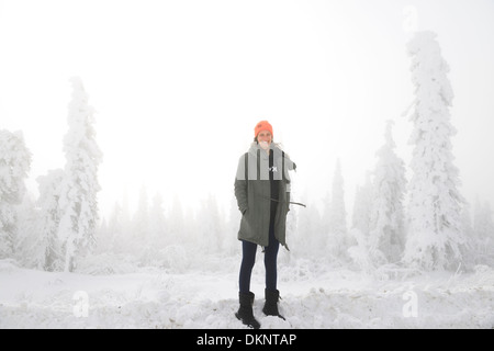 Weibliche Touristen auf einem Snowbank mit Schnee bedeckt, Bäume und Winternebel auf dem Dalton Highway Alaska USA Stockfoto