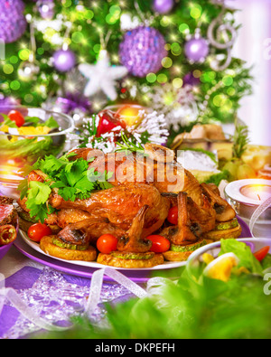 Traditionelle Weihnachts-Tabelle auf dekorierten Xmas Baum Hintergrund, leckeren Brathähnchen mit gebackenem Gemüse, Neujahr Stockfoto