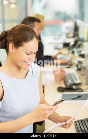 Geschäftsfrau mit Handy im Büro Stockfoto