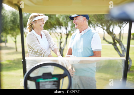 Älteres paar lachend auf Golfplatz Stockfoto