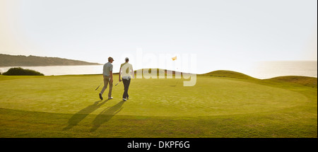 Männer gehen auf Golfplatz Stockfoto