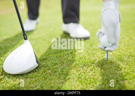 Mann Abschlag Golfball auf Kurs Stockfoto