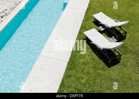 Sonnenliegen auf dem Rasen entlang Sportbecken Stockfoto