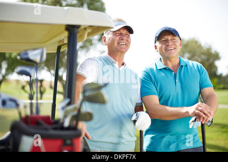 Ältere Mann stand neben Golf-cart Stockfoto
