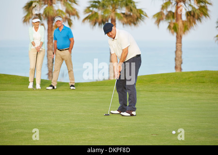 Senioren Freunde spielen Golf auf Kurs Stockfoto