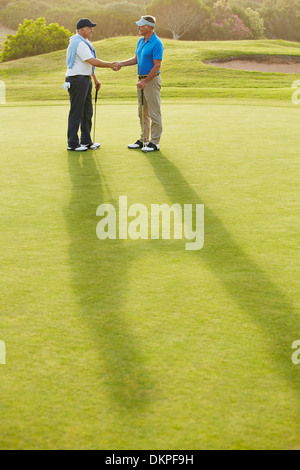 Senioren Herren Händeschütteln auf Golfplatz Stockfoto