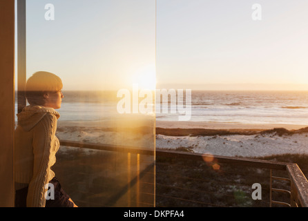 Frau beobachten Sonnenuntergang über Meer Stockfoto