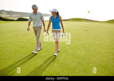 Paare, die auf Golfplatz Stockfoto