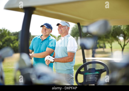 Senioren Herren stehen neben Golf-cart Stockfoto