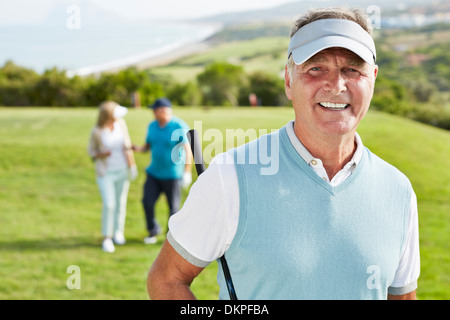 Lächelnder senior Mann auf Golfplatz Stockfoto