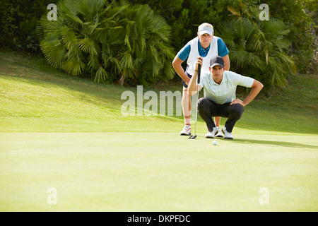 Caddy und Golfer Putten wird vorbereitet Stockfoto