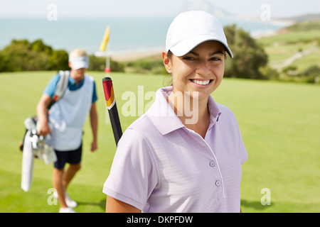 Lächelnde Frau auf Golfplatz Stockfoto