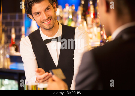 Gut gekleidete Barkeeper die Kreditkarte von Kunden in Luxus bar Stockfoto