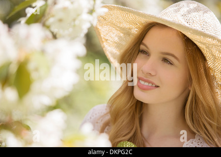 Frau, die Blumen im Freien zu bewundern Stockfoto