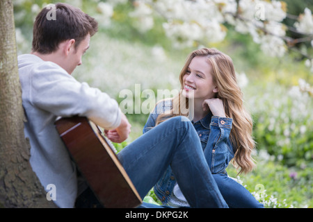 Gitarre spielen für Freundin im freien Mann Stockfoto