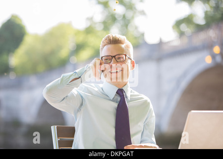 Geschäftsmann am Straßencafé am Handy sprechen Stockfoto