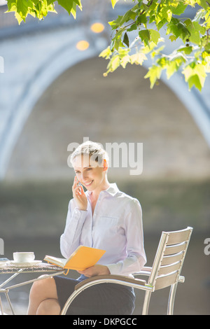 Geschäftsfrau, reden über Handy im Straßencafé Stockfoto