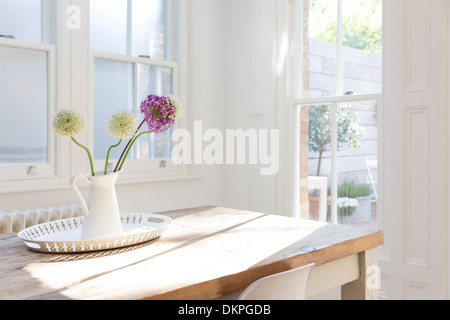 Blumen in Vase auf Holztisch Stockfoto