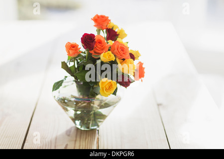 Nahaufnahme eines mehrfarbigen Rosen in Vase auf Tisch Stockfoto