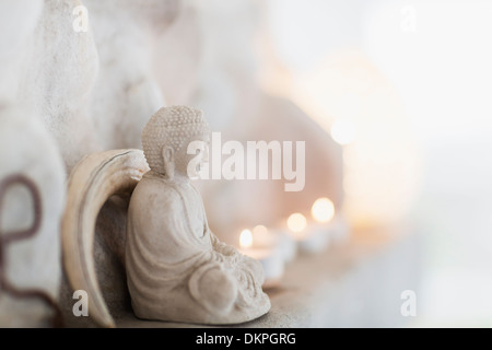 Buddha Figur und Kerzen auf Sims Stockfoto